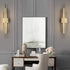 Modern LED wall lamp mounted on a wall with sleek gold and black design illuminating warm white light