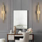 Modern LED wall lamp mounted on a wall with sleek gold and black design illuminating warm white light
