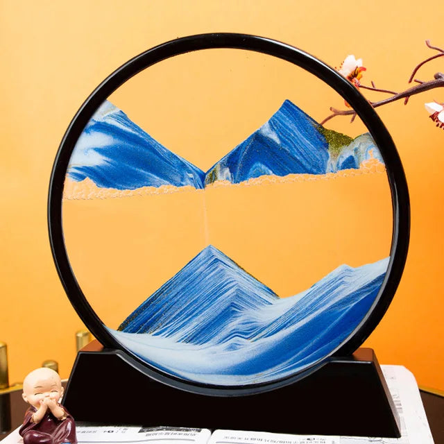 Sand Frame with black circular acrylic frame displaying blue and white textured sand art resembling mountains