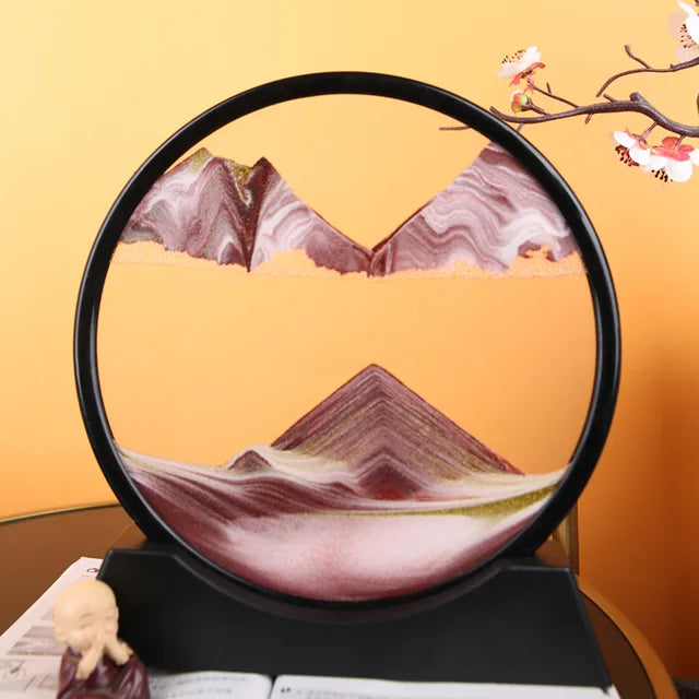 Sand Frame with black circular acrylic frame containing layered red, white, and green fine sand creating a textured mountain landscape design