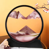 Sand Frame with black circular acrylic frame containing layered red, white, and green fine sand creating a textured mountain landscape design