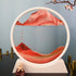 Sand Frame round white acrylic frame with red and orange multi-colored sand art forming layered patterns inside clear enclosure
