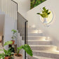 Wall Plant LED Lamp with white circular frame and integrated LED lighting holding a green potted plant mounted on a white wall