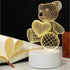 3D LED Lamp shaped like a teddy bear holding a heart, featuring a yellow optical illusion wireframe design on a white base