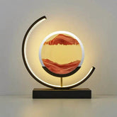 Sandscape LampIlluminate your space with the mesmerizing Sandscape of Time Lamp. Beyond its function as a lamp, this unique piece combines moving sands with a gentle LED glow, creAlphas lightAlphas lightSandscape Lamp