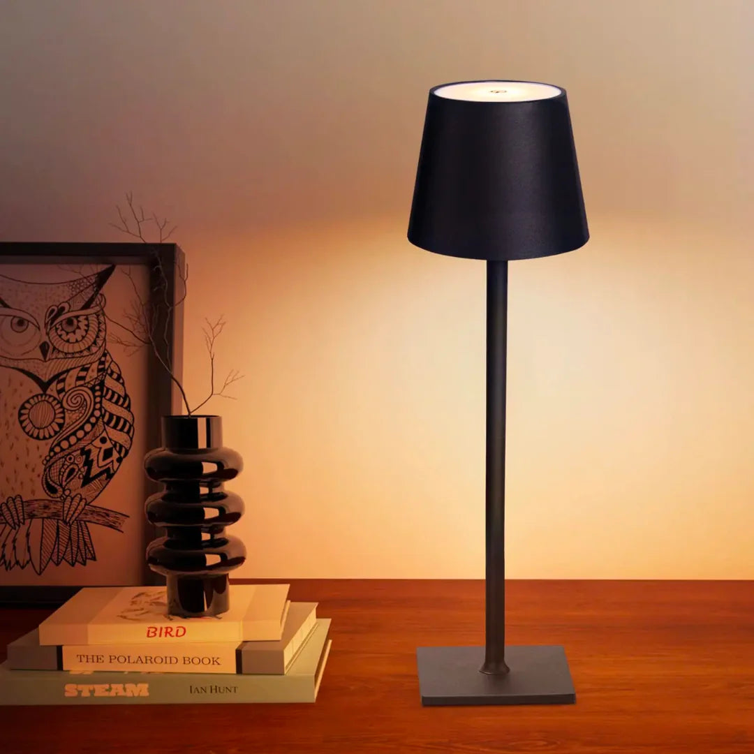 Cordless lamp with a sleek black metal base and shade, providing warm ambient lighting with a minimalist design.