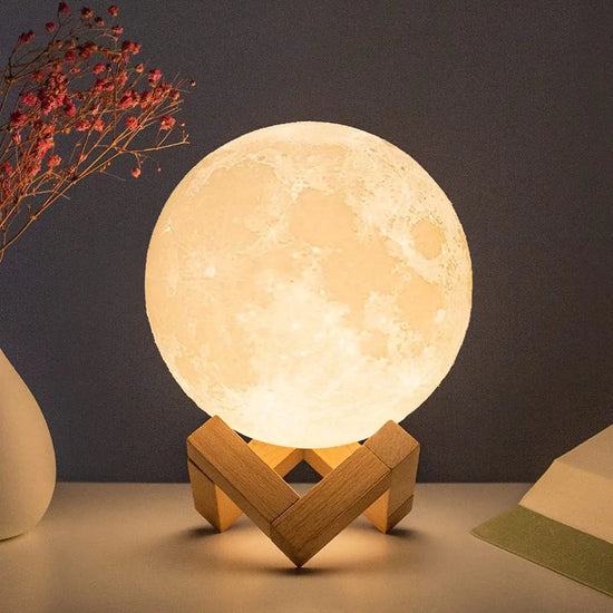 Moon Lamp with detailed lunar surface design on LED acrylic sphere, warm glowing light on natural wooden stand