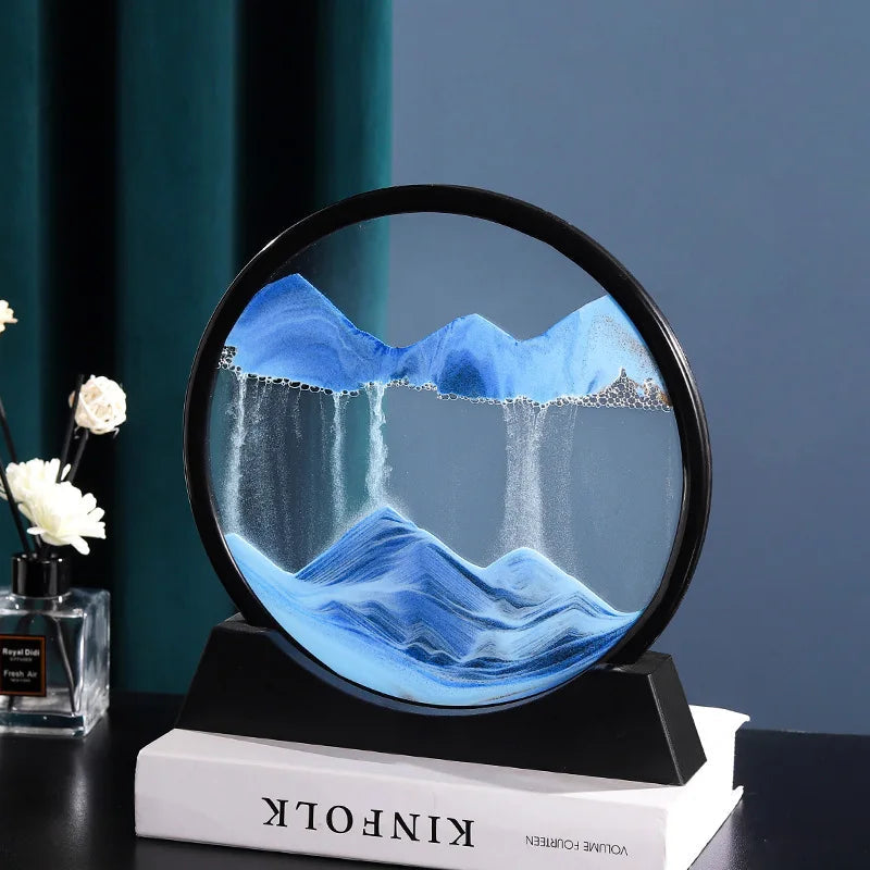 Sand Frame with black circular acrylic structure containing blue and white sand forming mountain and waterfall design inside a stand